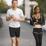A man and woman jogging together outside, embracing a healthy lifestyle.
