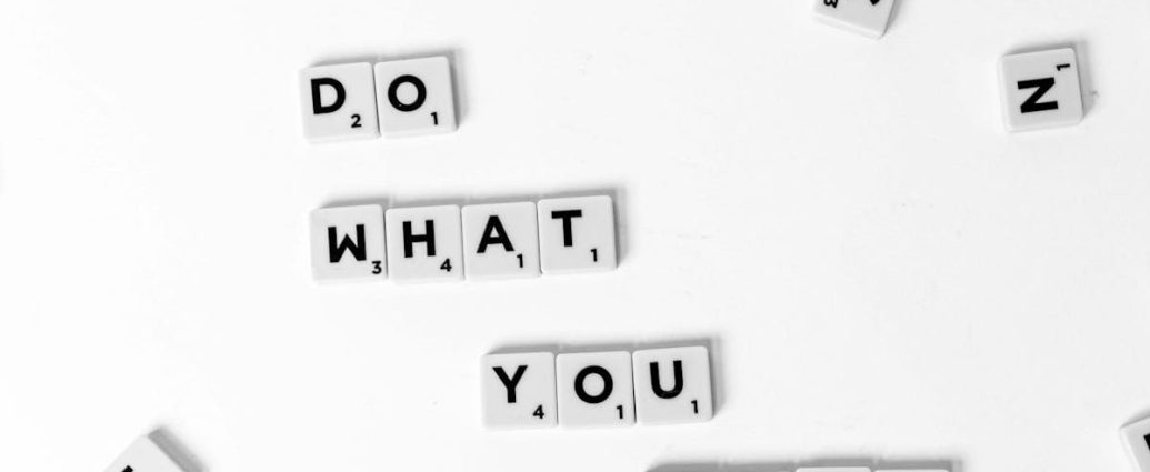 Scrabble tiles spelling 'Do What You Love' on a white background, encouraging creativity.